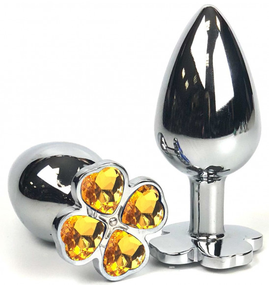 Серебристая анальная втулка с клевером из оранжевых кристаллов - 6 см. Серебристая анальная втулка с клевером из оранжевых кристаллов - 6 см.